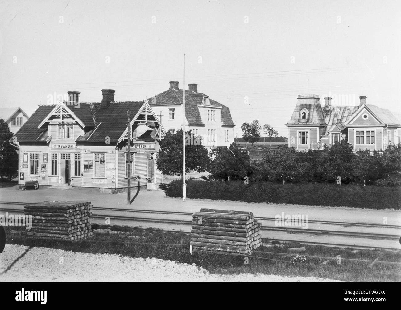 Bahnhof landschaftlich im Jahr 1900. Eineinhalb Etagen Holzhäuser. Mechanische Getriebe Boss stark hellgelb mit weißen Knoten Formteile und Futter, grüne Fenster und Türen. Weiße Zeichen, schwarzer Text. Rotes Ziegeldach und Kamin. Stockfoto