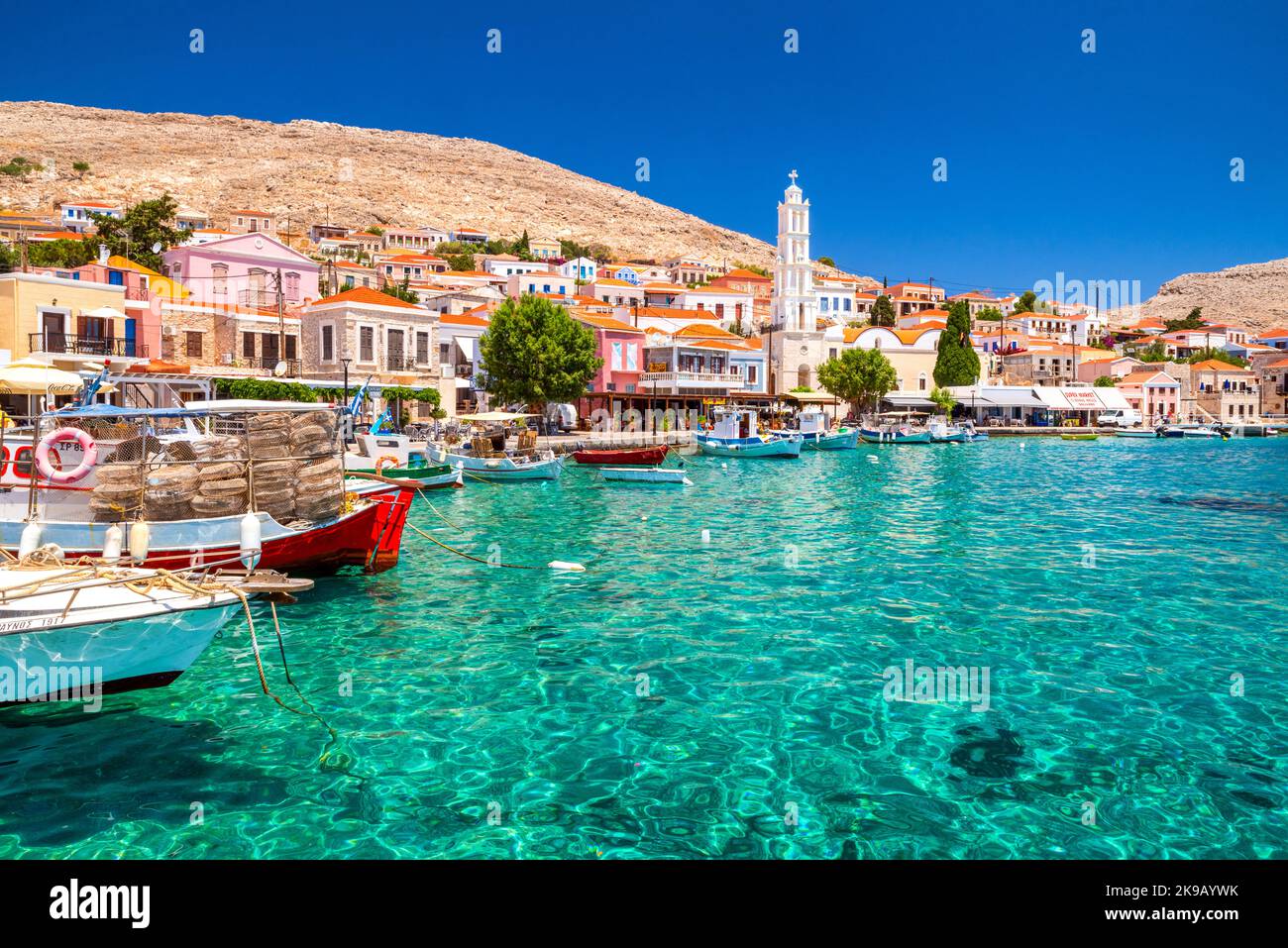 Halki, Griechenland - 6. Juli 2022: Bunte Häuser und Fischerboote auf der malerischen kleinen Insel Halki (Chalki) in Griechenland Stockfoto