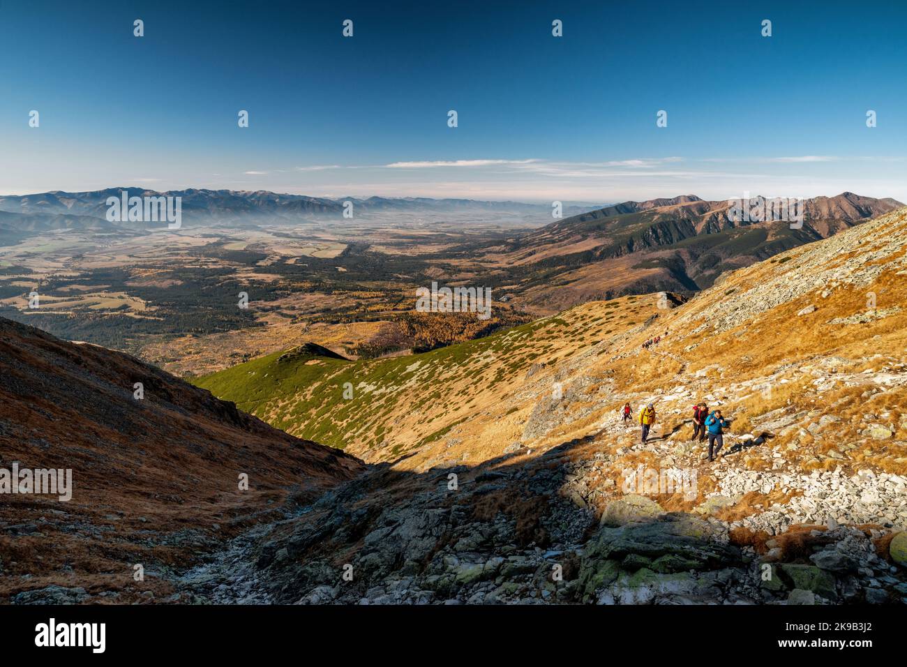 PODBANSKE, SLOWAKEI - 31. OKTOBER 2021: Touristen wandern auf dem Bergweg zum Gipfel Krivan in der Hohen Tatra. Westliche Tatra im Hintergrund Stockfoto