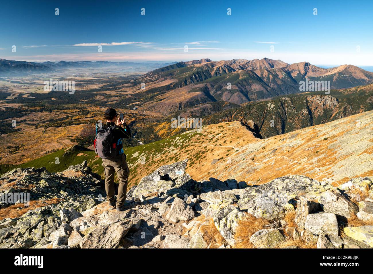 Wanderer auf dem Gipfel Krivan in der Hohen Tatra macht Bild von der schönen Berglandschaft in der Slowakei. Stockfoto