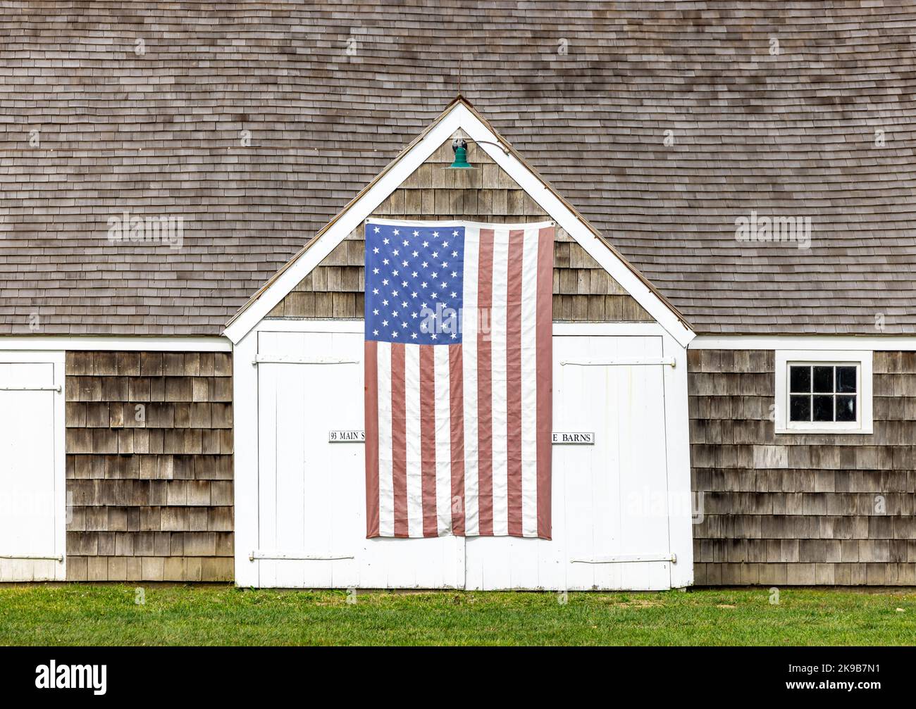 Alte Wainscott-Scheune mit einer amerikanischen Flagge an der Vorderseite Stockfoto