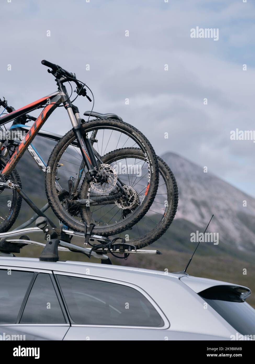 Mountainbikes auf einem Autodach in einer schottischen Berglandschaft, Schottland Großbritannien Stockfoto