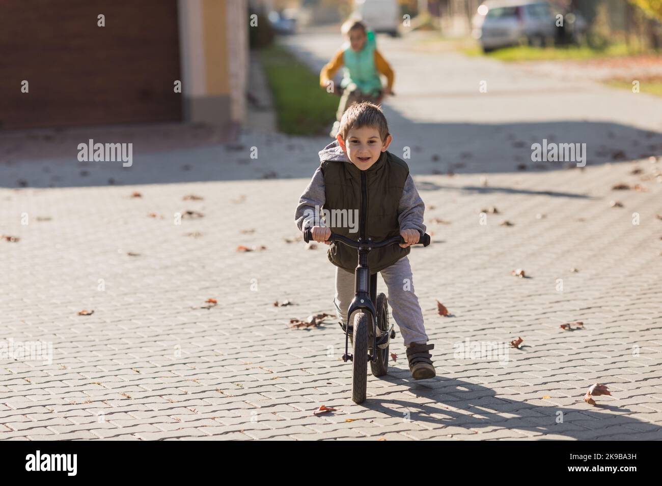 Junge am Fahrrad läuft auf der Straße Stockfoto