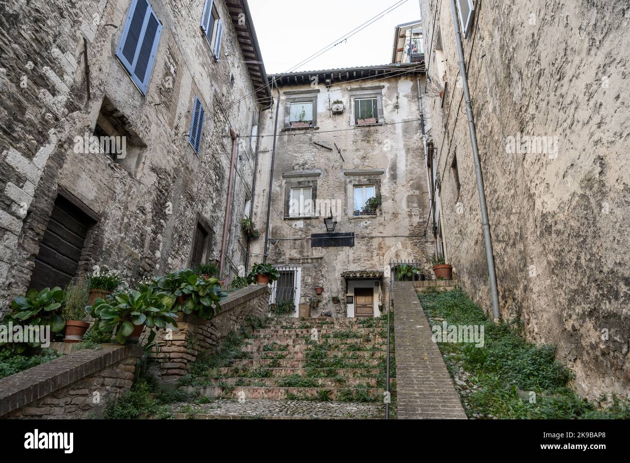 Eine typische Straßenszene in der Altstadt von Spoleto mit traditionellen Steinhäusern und Treppen, die am frühen Morgen fotografiert wurden. Umbrien, Italien. Stockfoto