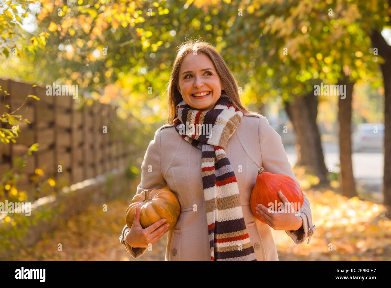 Porträt einer glücklichen Frau mit Kürbissen in der Hand. Stockfoto