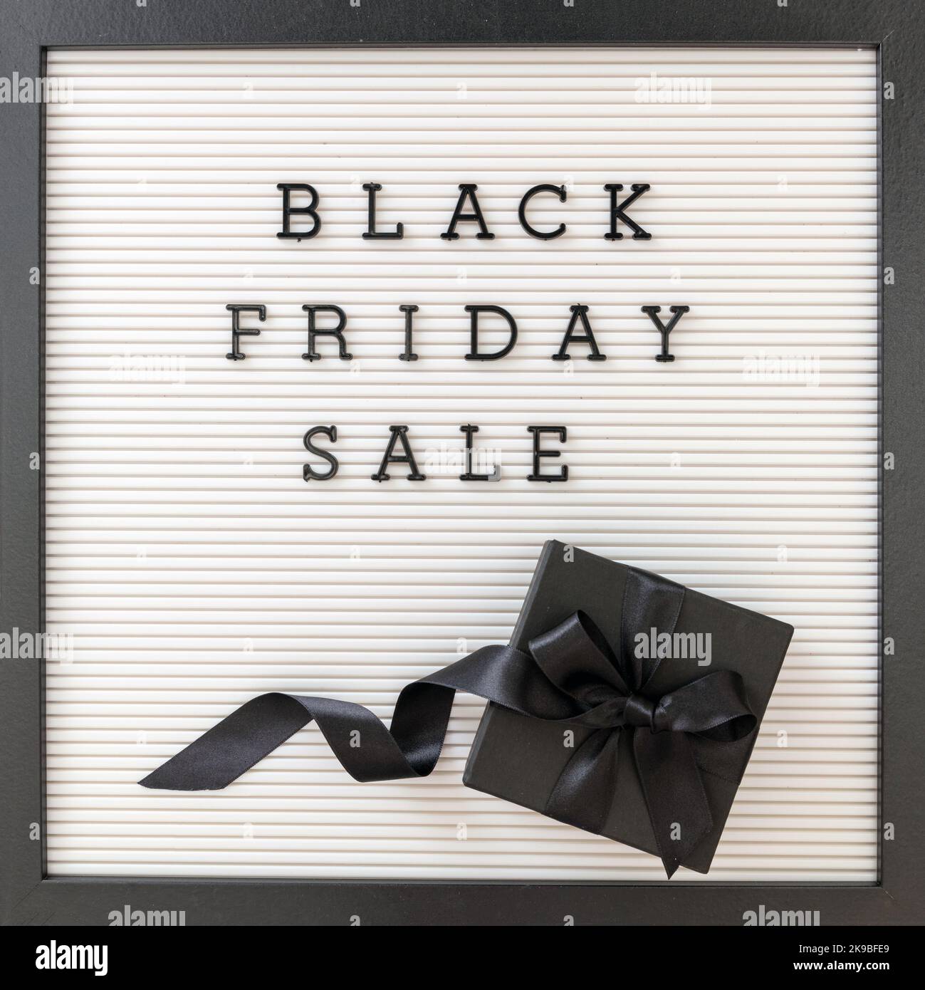 Black Friday Sale Text und Geschenkbox mit Band, Draufsicht. Weihnachtsgeschenke Angebote, saisonale Verkäufe Stockfoto