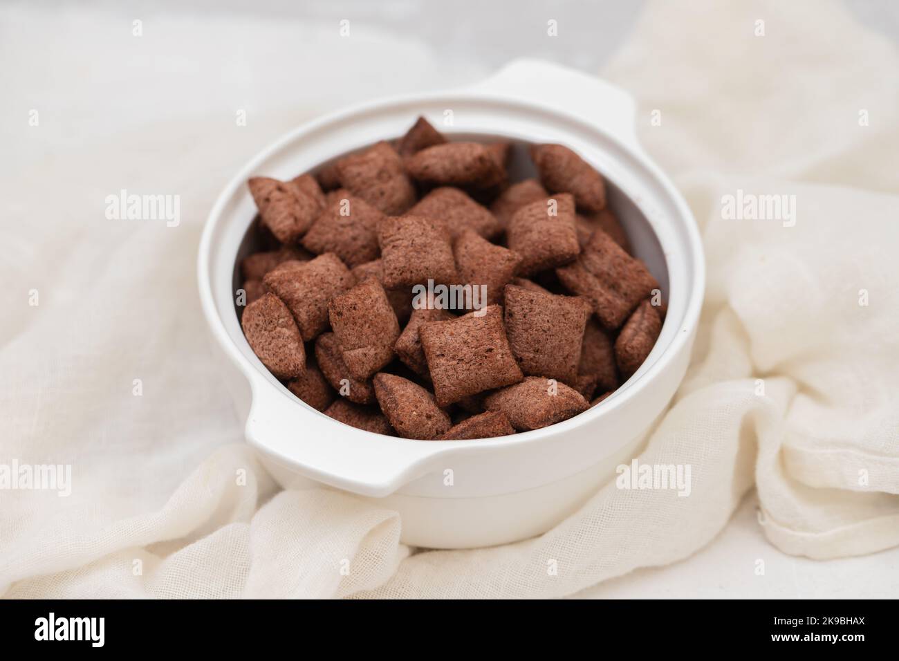 Schokoladengetreide in kleiner weißer Schale auf Keramik Stockfoto