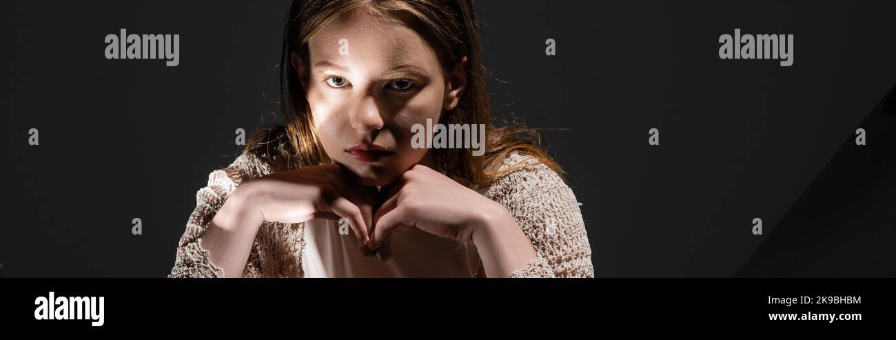 Hellhaarige Modell in beige Strickjacke Blick auf die Kamera auf grauem Hintergrund mit hellem, Banner Stockfoto