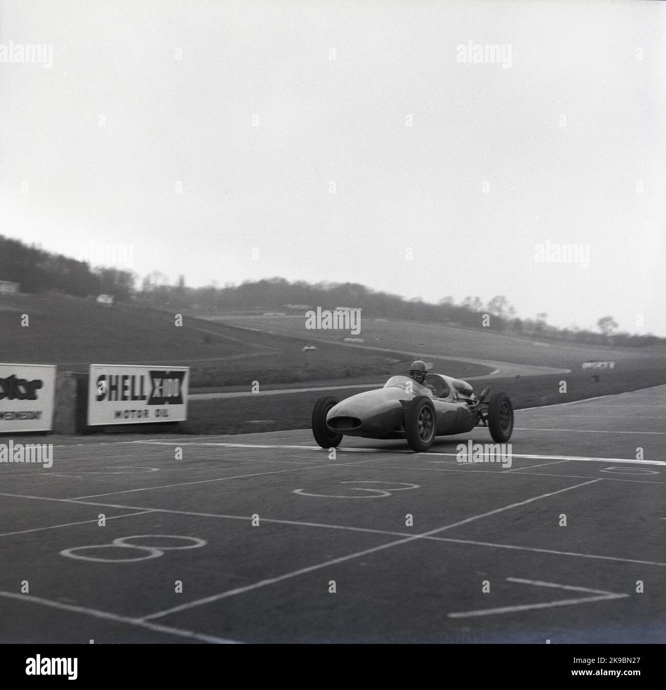 1959, historisch, ein Cooper-Rennwagen, der die Ziellinie auf der Rennstrecke von Brands Hatch, Kent, England, Großbritannien, überquert. Zu dieser Zeit befand sich auf dem Zirkuit die Cooper's Racing Driver's School. Stockfoto