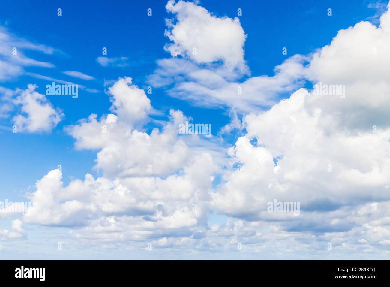 Wolkiger Himmel an einem sonnigen Tag. Cumulus und Altocumulus Arten von Wolken. Natürliches Hintergrundfoto Stockfoto