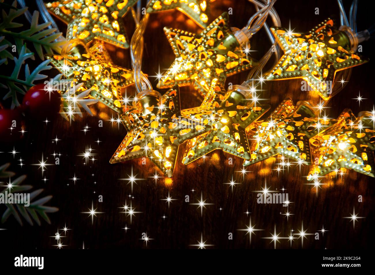 Weihnachtsdekoration - Goldene Kugeln und Sterne auf Holzhintergrund mit anpassbarem Platz für Text. Speicherplatz kopieren. Stockfoto