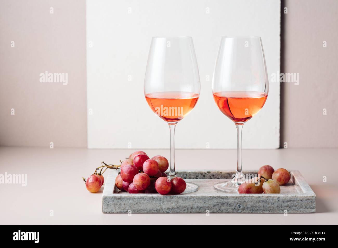 Zwei Gläser Roséwein und ein paar rote Trauben. Stockfoto