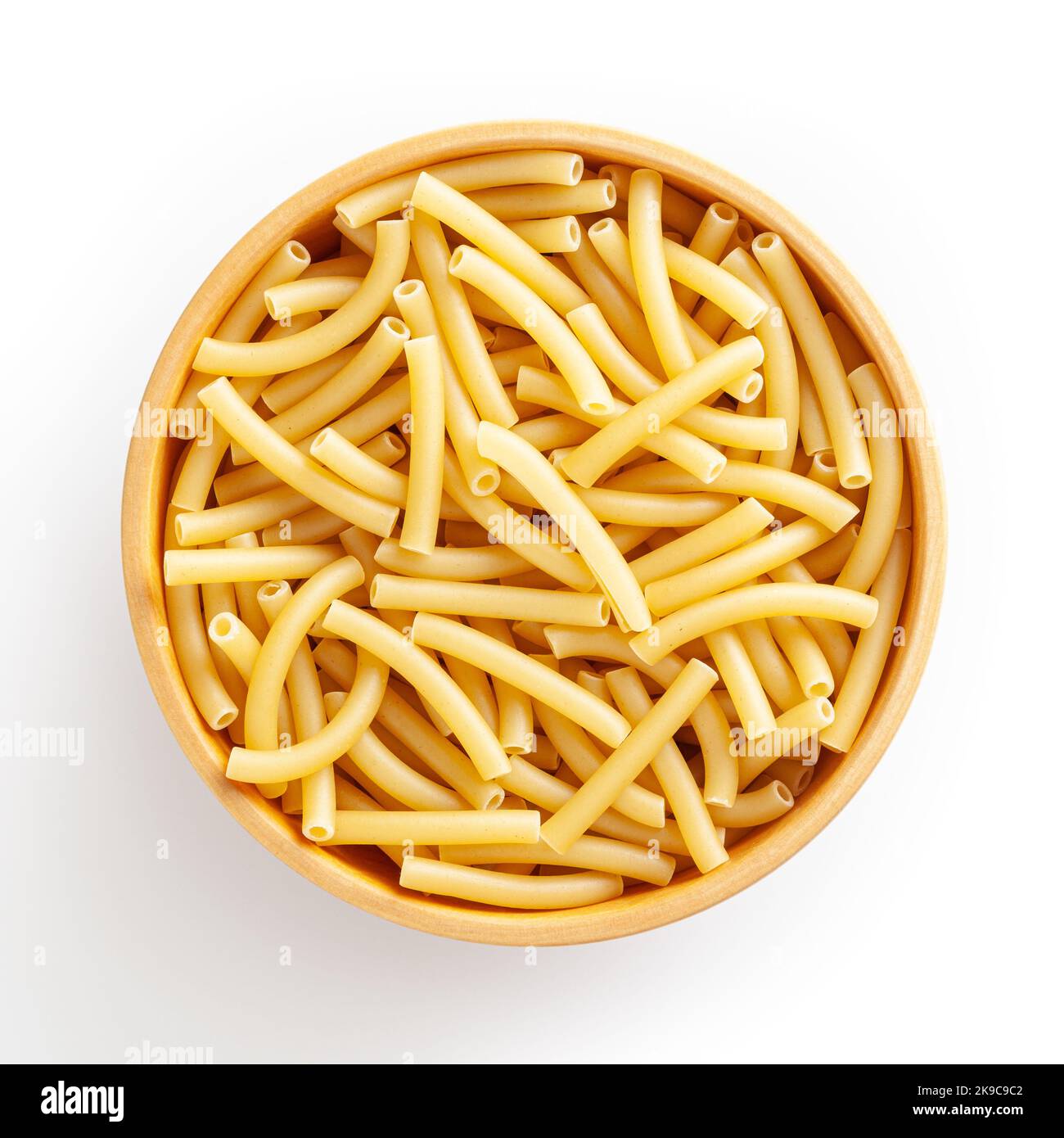 Ungekochte Makcheroni-Pasta in Holzschüssel isoliert auf weißem Hintergrund mit Schneideweg Stockfoto