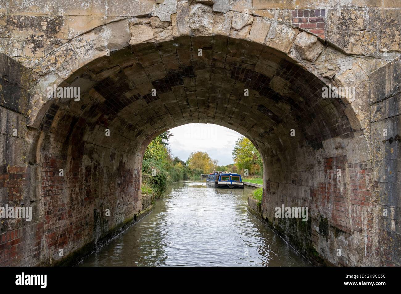 Unter der Seend Lock Bridge auf einem grünen Kahn; am Seend Top Lock am Kennet und Avon Canal, Wiltshire, Großbritannien. Stockfoto