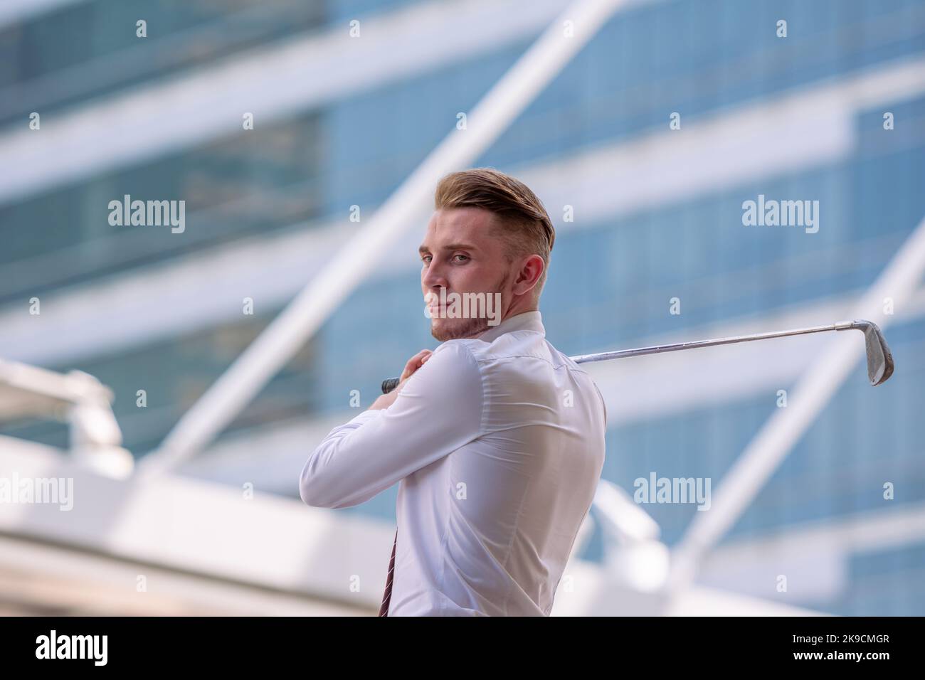 Junger, selbstbewusster CEO-Geschäftsmann mit weißem Hemd und Golfclub in der Stadt. Stockfoto