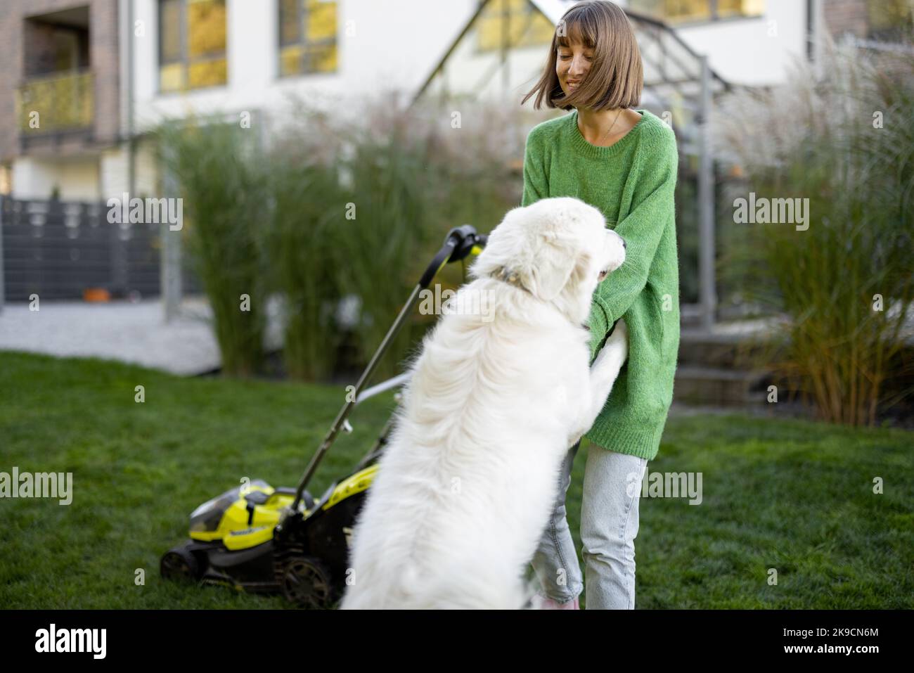 Frau spielt mit ihrem Hund im Garten Stockfoto