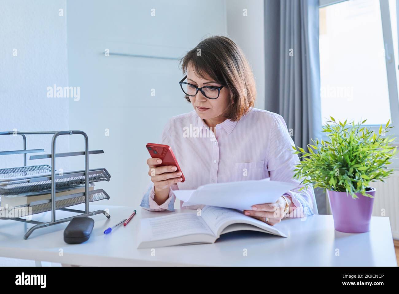 Geschäftsfrau mittleren Alters, die zu Hause arbeitet Stockfoto