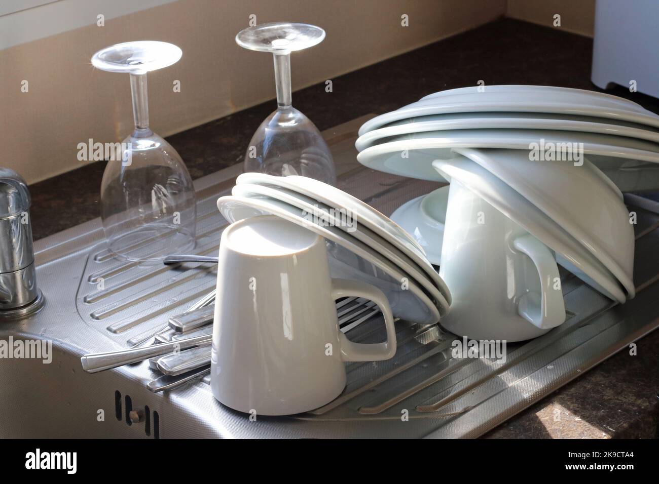 Abspülen auf einem Abtropfbrett. Tassen, Teller und Gläser reinigen. Stockfoto