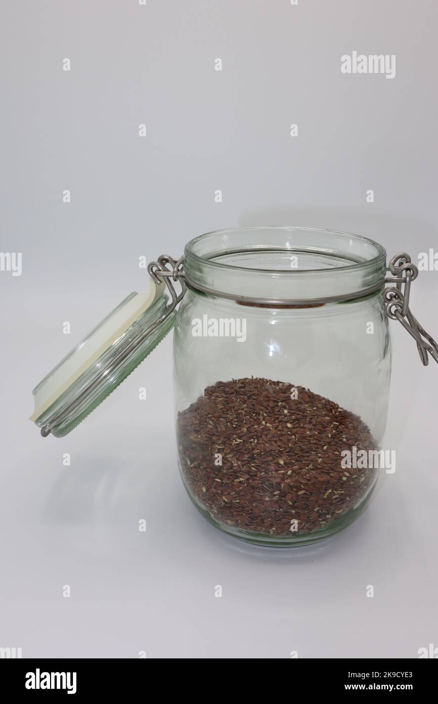 Glas gefüllt mit getrockneten Leinsamen auf weißem Hintergrund Stockfoto