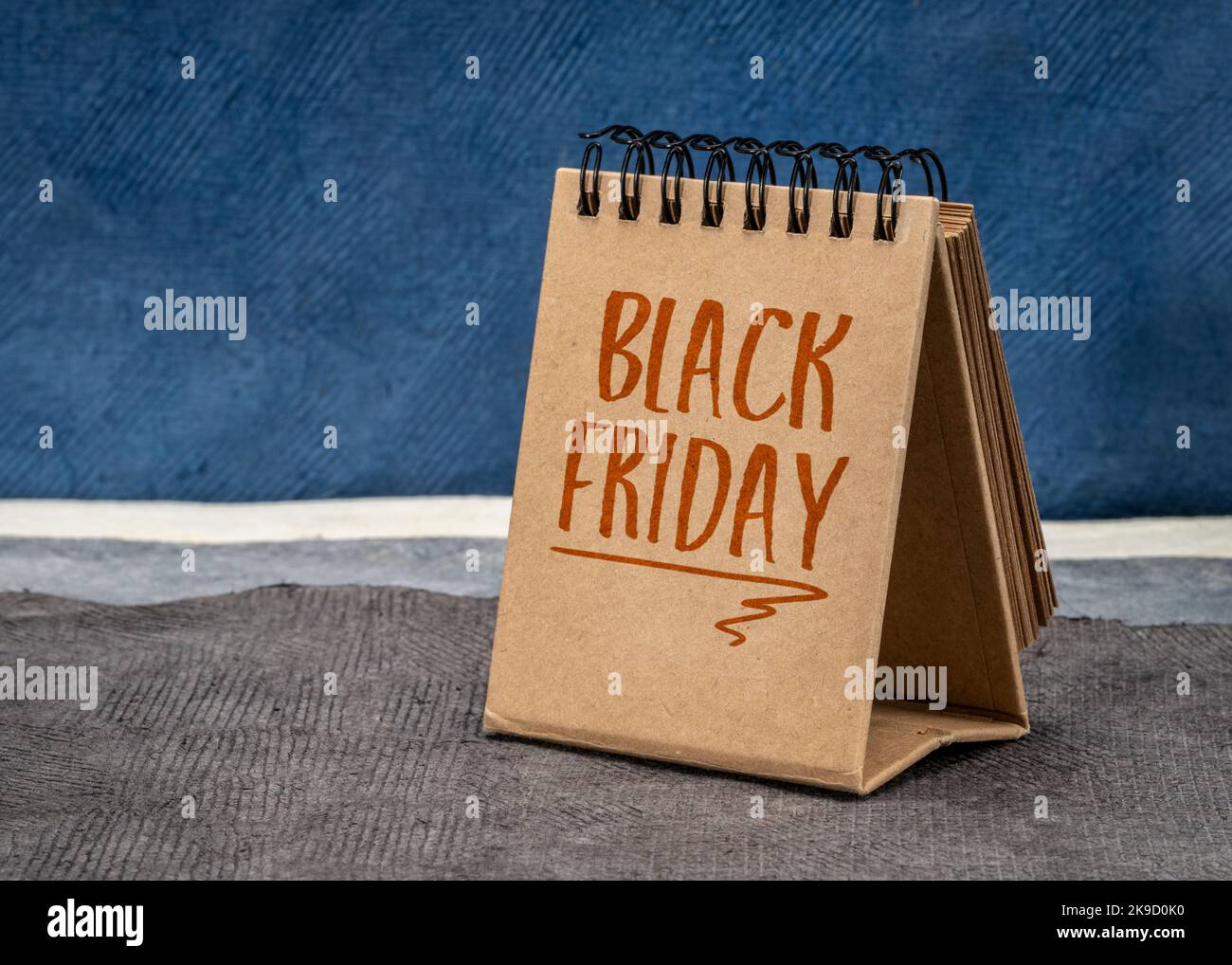 Black Friday-Erinnerung in einem Desktop-Kalender gegen abstrakte Papierlandschaft, Herbstferien und Einkaufskonzept Stockfoto
