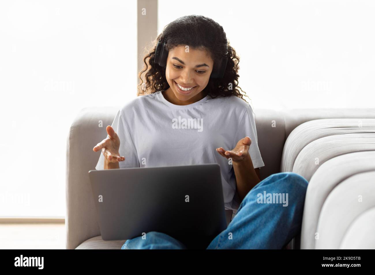 Afroamerikanische Hipster-Frau mit Afro-Haar mit Laptop im Gespräch mit Webcam mit Freund online Videoanruf Stockfoto
