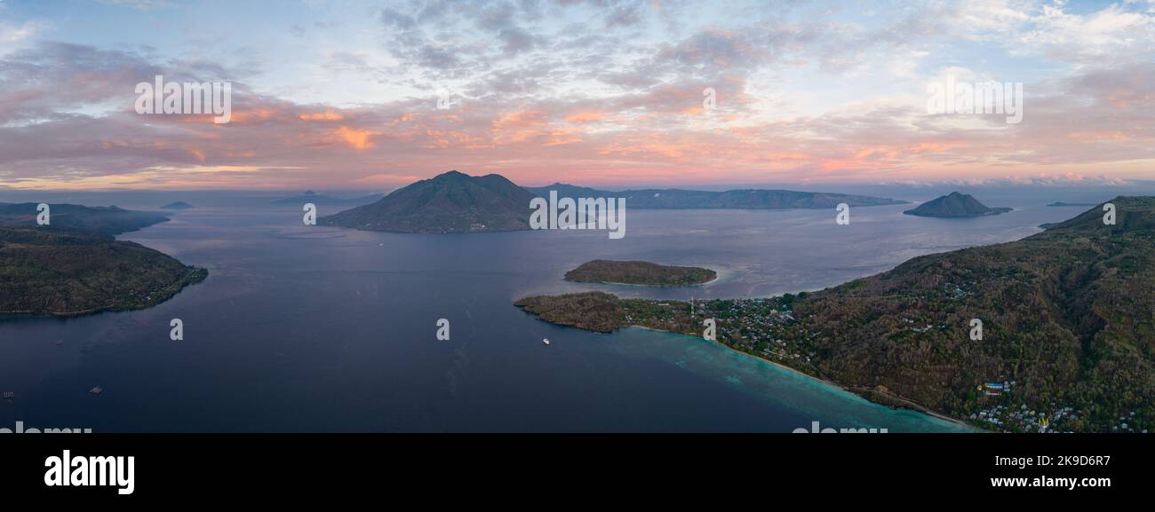 Sonnenaufgang beleuchtet Alor und Vulkane in der Pantar-Straße, Indonesien. Diese wunderschöne Region ist für ihre hohe marine Artenvielfalt bekannt. Stockfoto