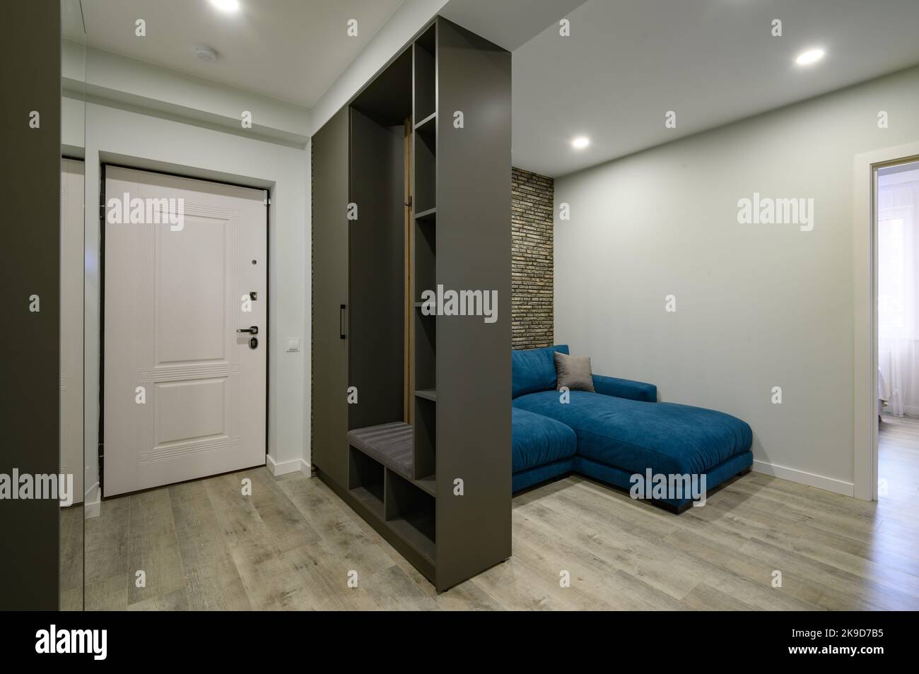 Die Eingangshalle ist an ein kleines modernes Wohnzimmer angeschlossen Stockfoto