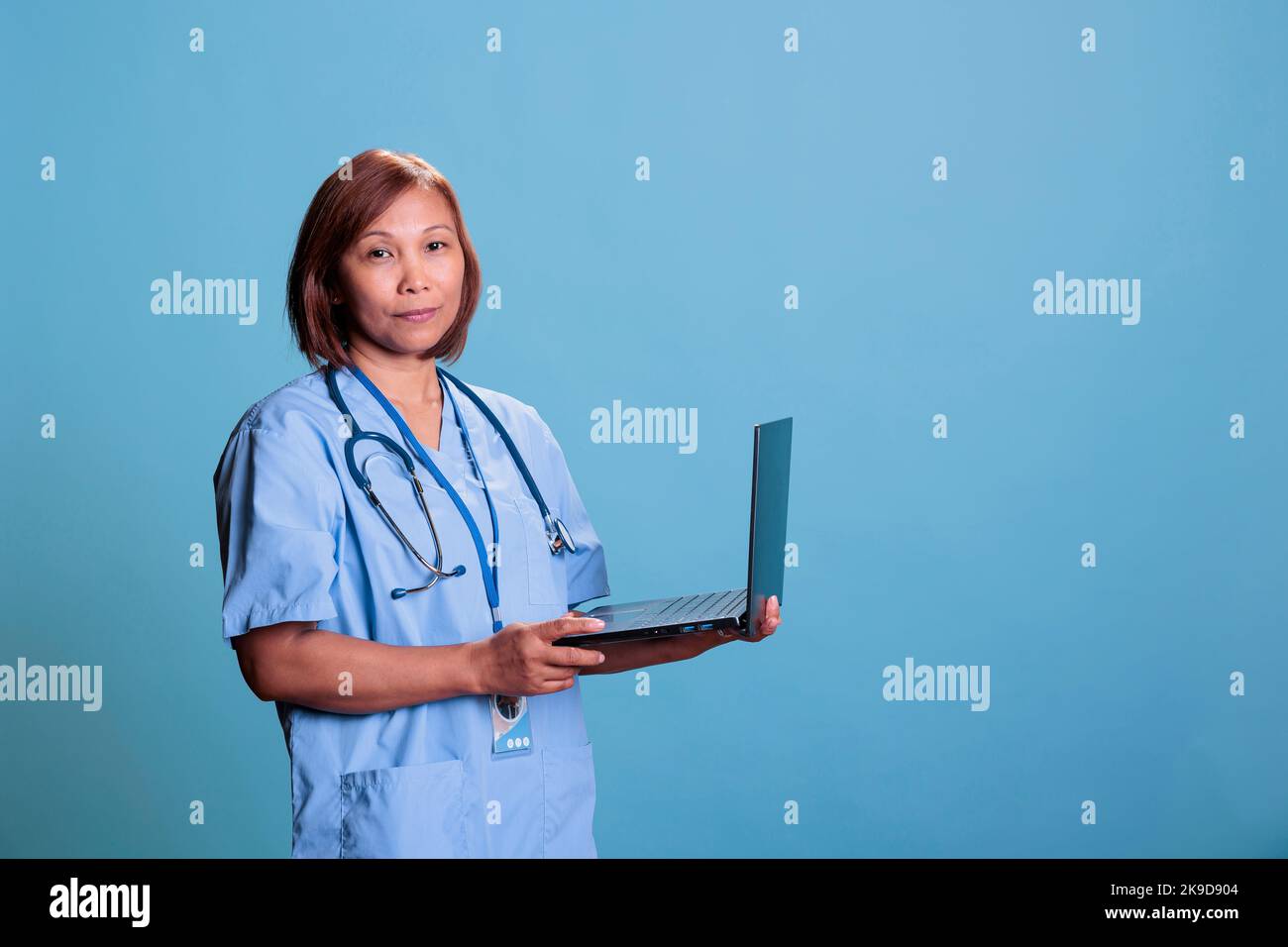 Medizinischer Assistent, der medizinische Verschreibung auf Laptop-Computer eingibt und die Gesundheitsbehandlung während des Kontrollbesuches im Studio plant. Asiatische Ärztin Krankenschwester mit Stethoskop bereit für die Konsultation Stockfoto