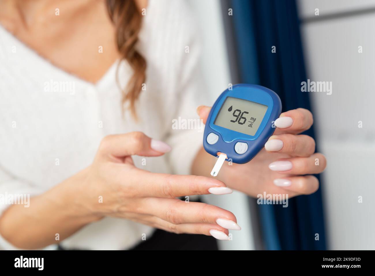 Frau, die Glucometer, Diabetes-Gesundheitskonzept, Blutzuckermessung verwendet. Stockfoto