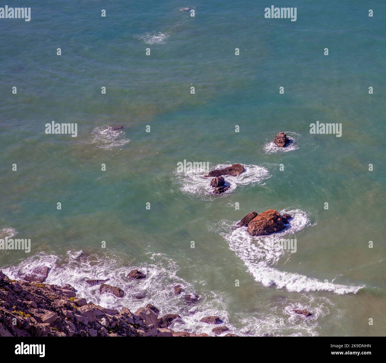 Wellen und Felsen im Meer vor der Küste mit Kopierraum Stockfoto