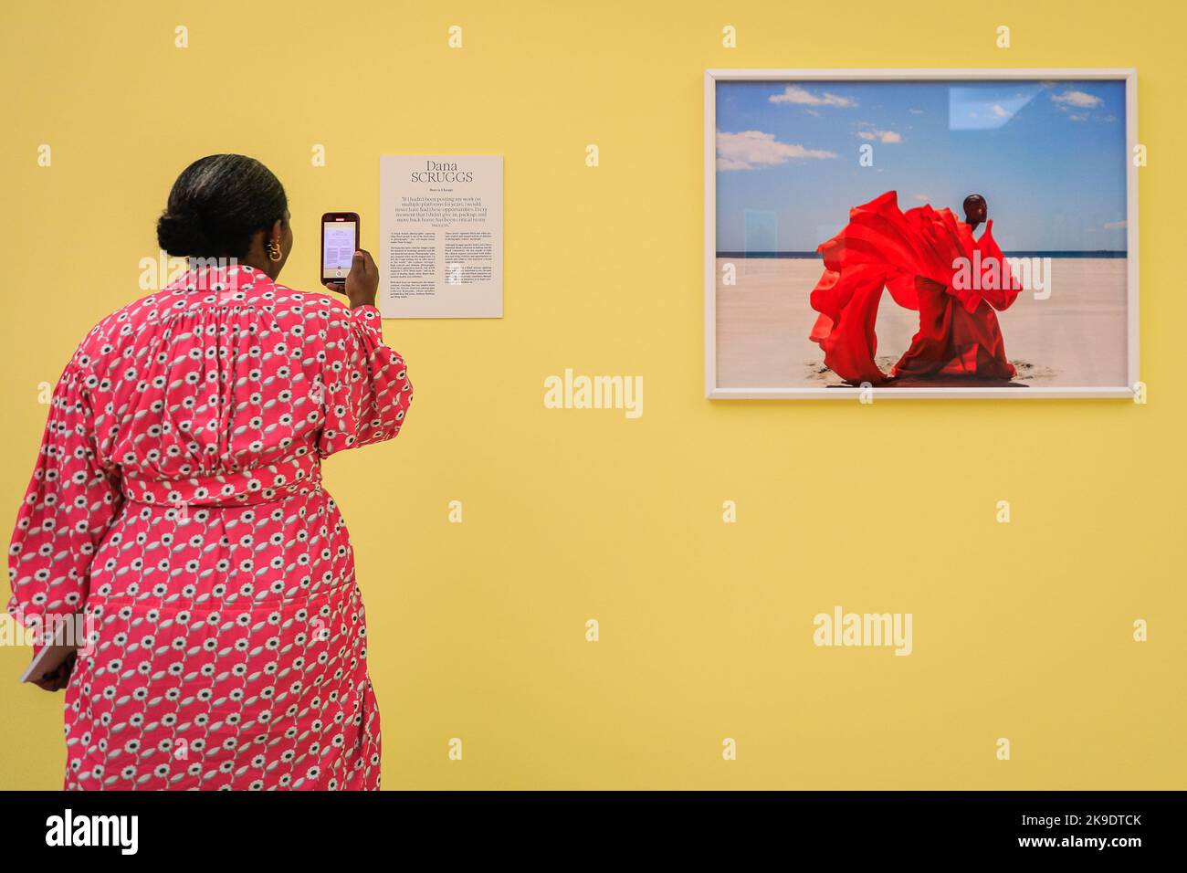 London, Großbritannien. 27. Oktober 2022. Ein Journalist fotografiert Dana Scruggs' 'Fire on the Beach', 2019. Geladene Gäste und Künstler mischen sich und posieren mit den Bildern. Privatansicht der neuen Ausstellung 'The New Black Vanguard: Photography between Art and Fashion' in der Saatchi Gallery in London, unterstützt von Burberry. Die Ausstellung zeigt 15 internationale Black-Fotografen und ist eine Hommage an die Kreativität der Schwarzen vor und hinter der Kamera, die bis zum 22. Januar 2023 läuft. Kredit: Imageplotter/Alamy Live Nachrichten Stockfoto