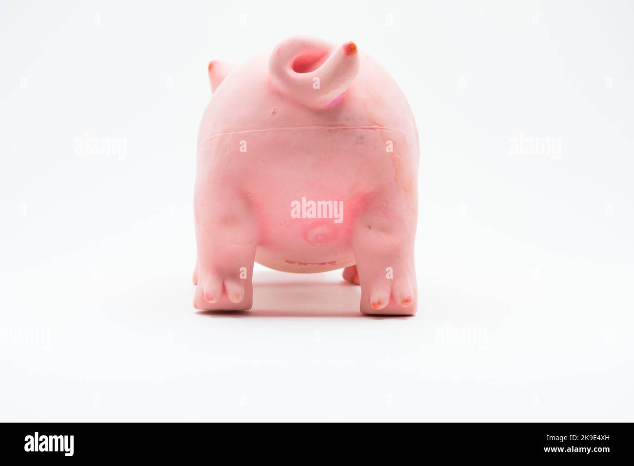 Rückansicht von Kunststoff-Schweinchen-Spielzeug auf weiß Stockfoto