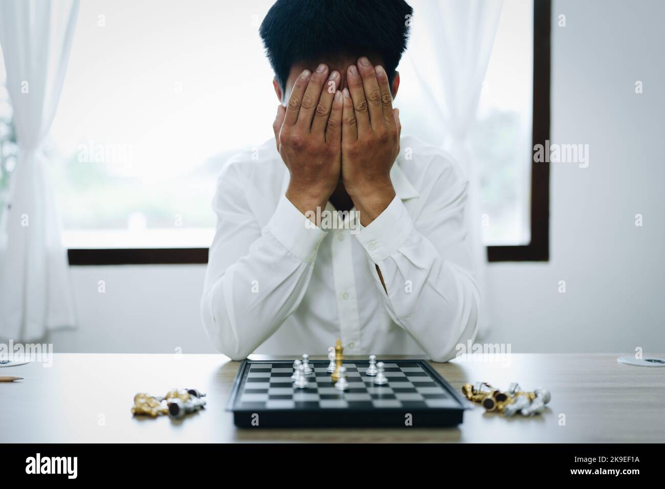Beim Spielen und Planen eines Schachspaziergangs zeigen Unternehmer eine Niederlage bei der Planung ihrer finanziellen Angelegenheiten Stockfoto