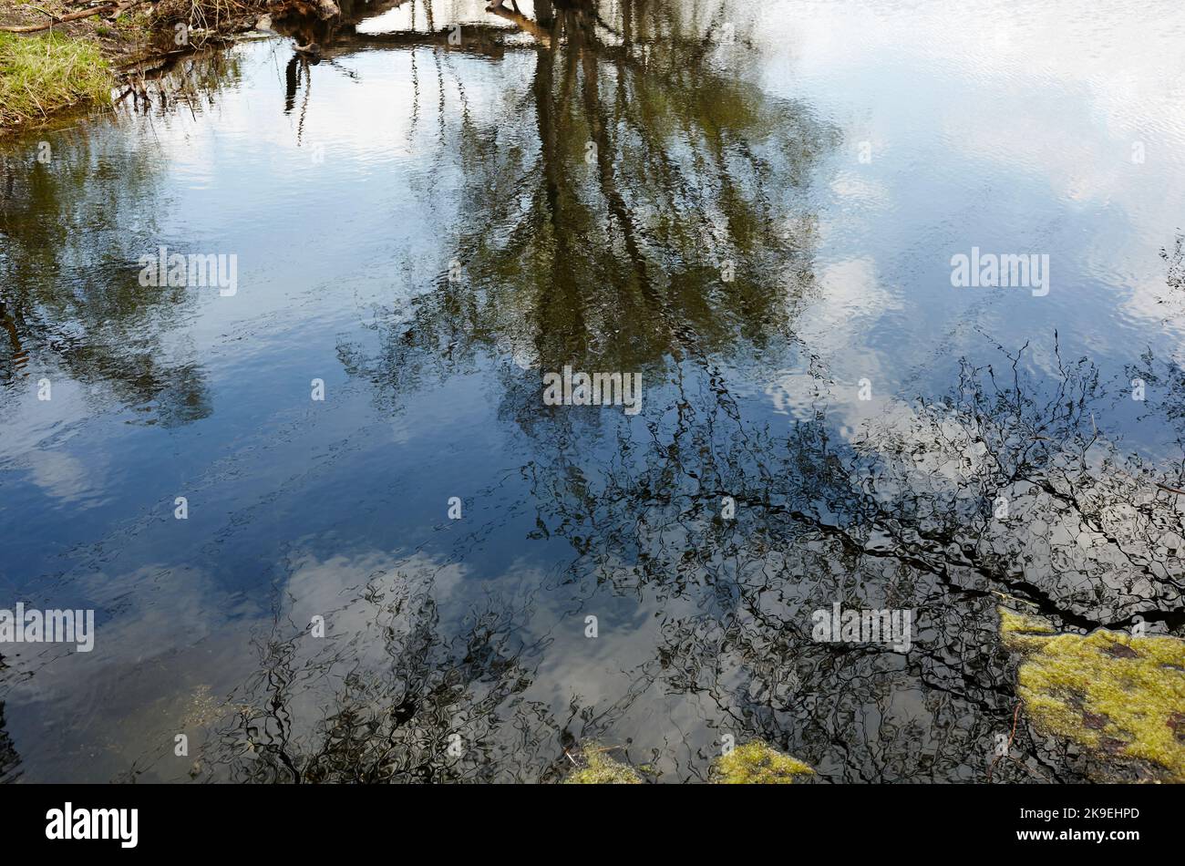 Wunderschöne Flusslandschaft. Reflexion im Wasser des Flusses. Lake Surface an einem sonnigen perfekten Tag. Verschwommenes Bild, selektiver Fokus Stockfoto