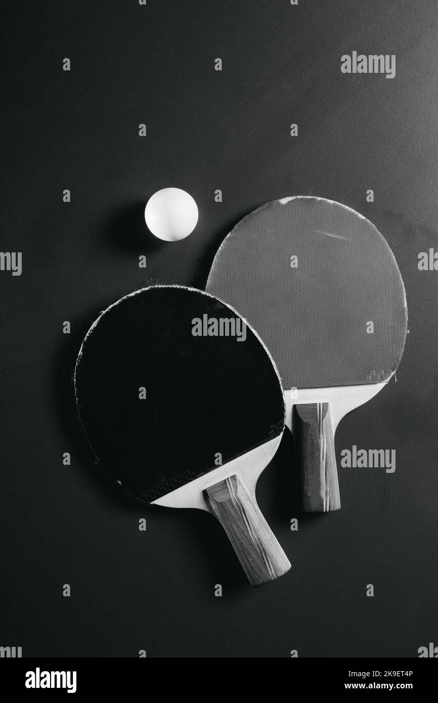 Zwei Tischtennisschläger und ein Ball befinden sich auf dem grünen Spieltisch Stockfoto