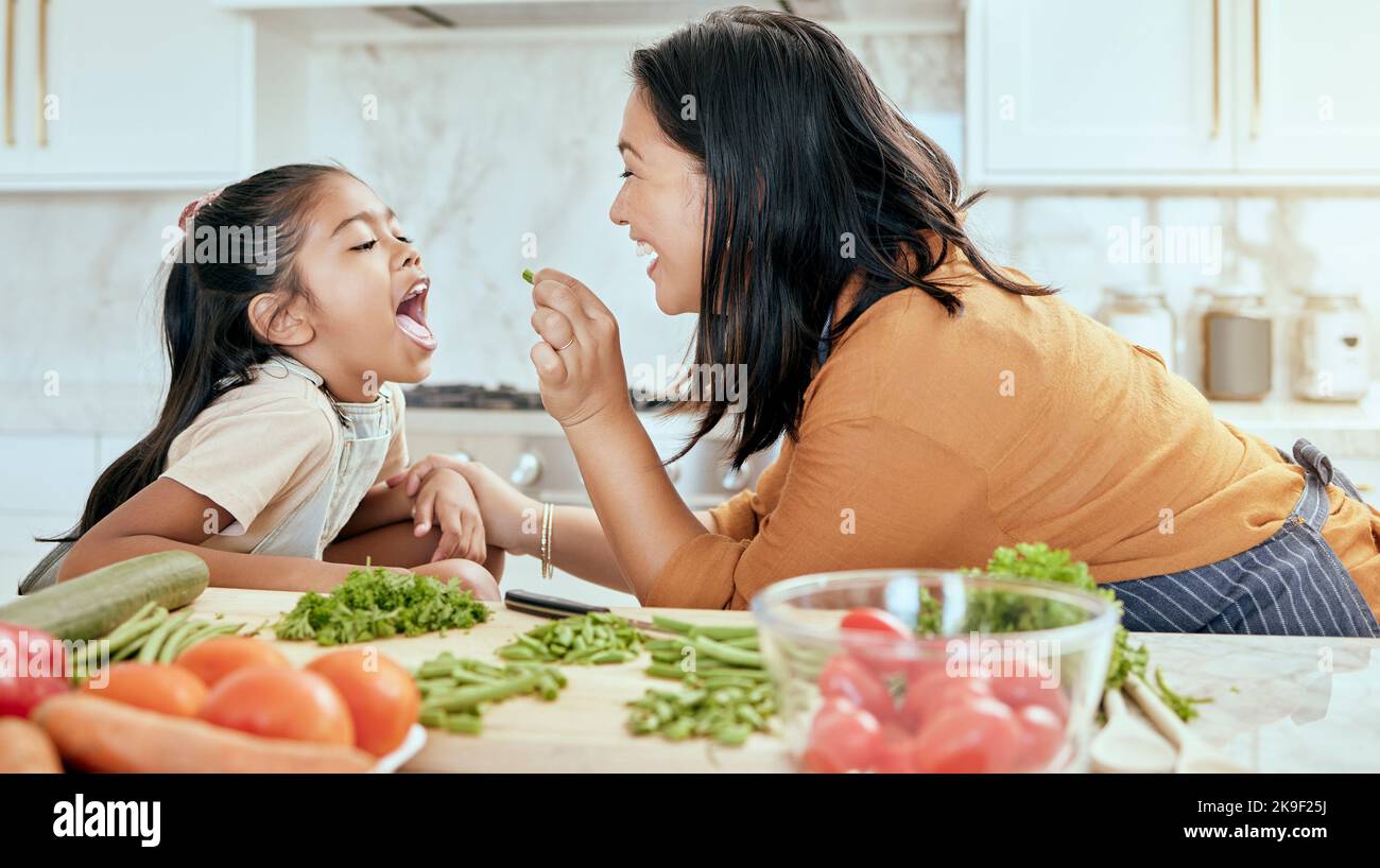 Gesundheit, Essen und Essen mit Mutter Kochen in der Küche mit Ernährung, Gemüse und Pflege. Startseite, Mittagessen und gesunde Ernährung der asiatischen Familie mit jungen Stockfoto