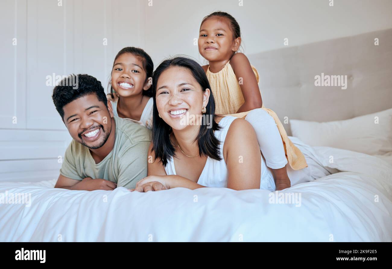 Glückliche Familie mit Kindern, lächeln und liegen zu Hause auf dem Bett, Portrait von Mutter, Vater und Kindern zusammen in Asien. Liebe, Spaß und Familie Zeit für Papa Stockfoto