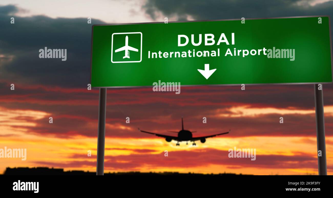 Flugzeug Silhouette Landung in Dubai Vereinigte Arabische Emirate. Ankunft in der Stadt mit Schild Richtung Flughafen und Sonnenuntergang im Hintergrund. Reise und Transport Stockfoto