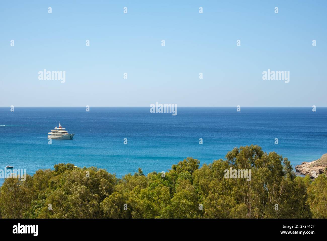 IOS, Griechenland - 9. September 2022 : Blick auf eine wunderschöne, von Bäumen umgebene Yacht am Strand von Mylopotas in iOS Griechenland Stockfoto