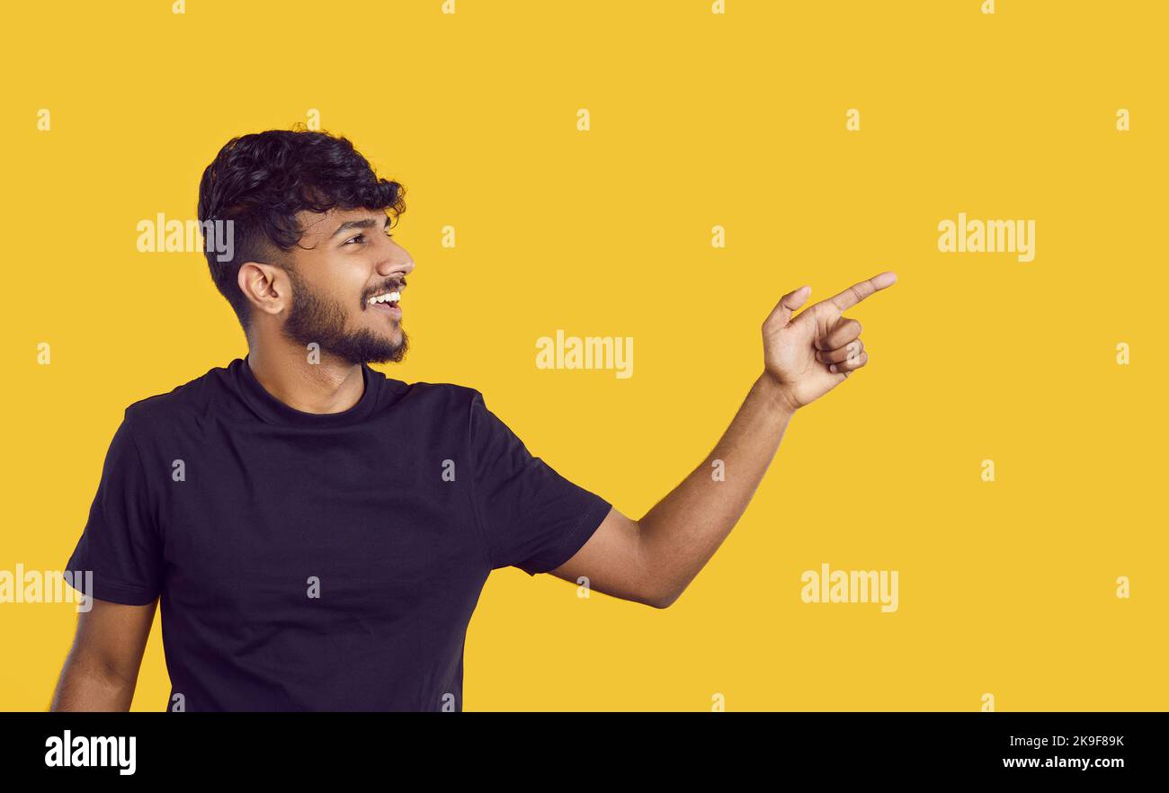 Fröhlicher indischer Kerl präsentiert Ihnen gutes Angebot oder Promotion-Deal auf Banner-Hintergrund. Stockfoto