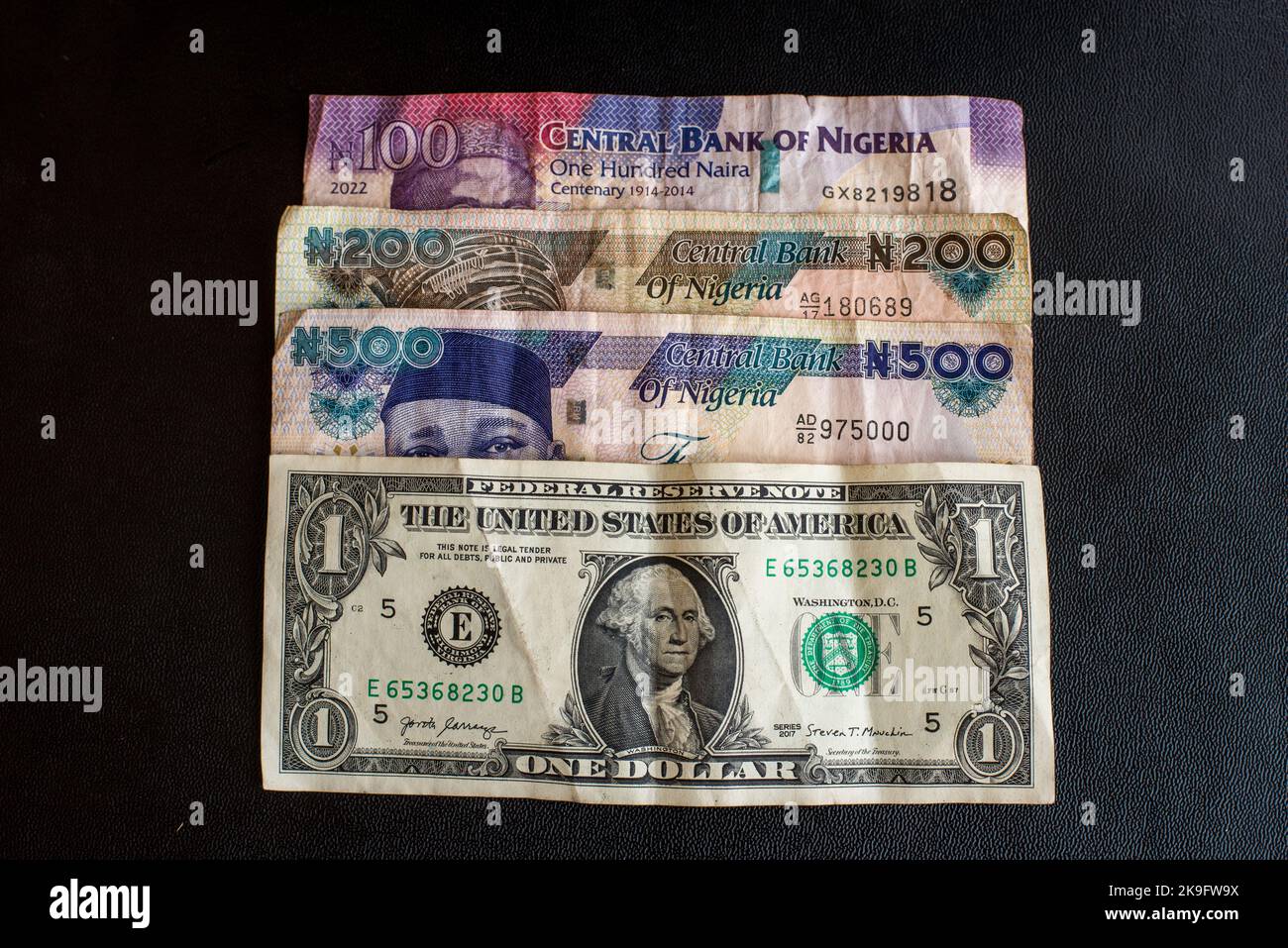 Eine große Menge nigrischer Banknoten und ein Doller-Schein. Nigrische Banknoten aus nächster Nähe. Reichhaltiges Lebenskonzept Stockfoto