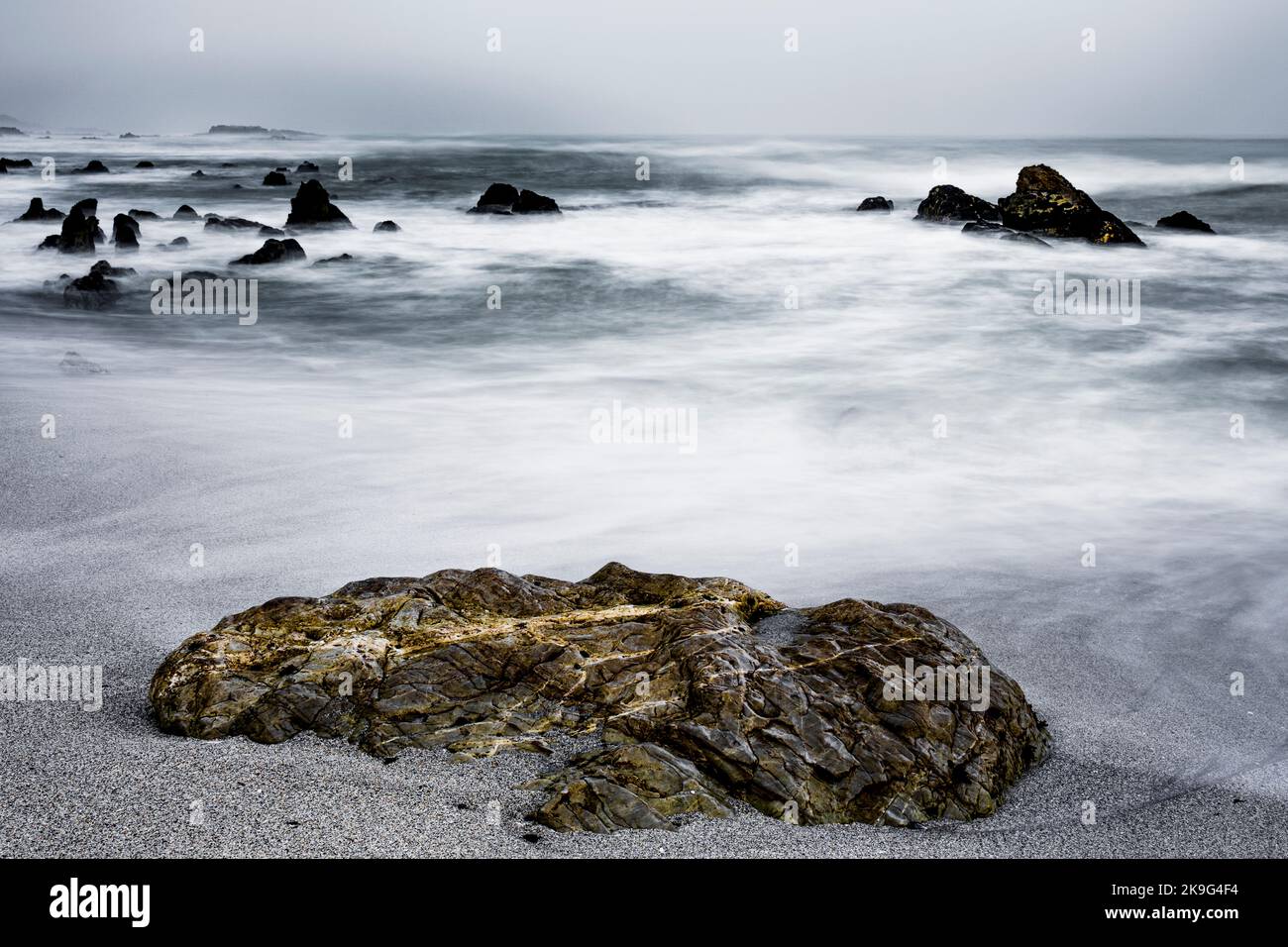 Die Moody Skulpiesbaai Seeskap unter einem brütenden Himmel verschwommen das Wasser und die Wellen wegen langer Aufnahmen. Hermanus, Whale Coast, Overberg, Western Cape Stockfoto