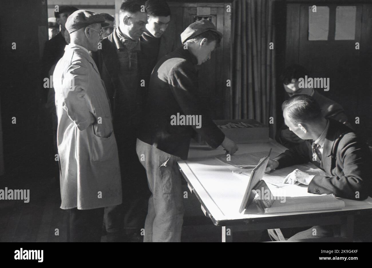 1938, historisch, Arbeiter in Büros/am Arbeitsplatz für Wochenlohn, Treforest Industrial Estate, Rhondda, South Wales, Großbritannien. Die Ursprünge des Anwesens liegen bei der South Wales & Monmouthshire Trading Estates Ltd, einem gemeinnützigen Regierungsunternehmen, das gegründet wurde, um Arbeitsplätze in der Region abseits der traditionellen Kohle- und Stahlindustrie zu schaffen und zu diversifizieren, die sich langfristig im Niedergang befanden. Mitte 1940s waren rund 16.000 Menschen auf dem Handelsgut beschäftigt. Stockfoto