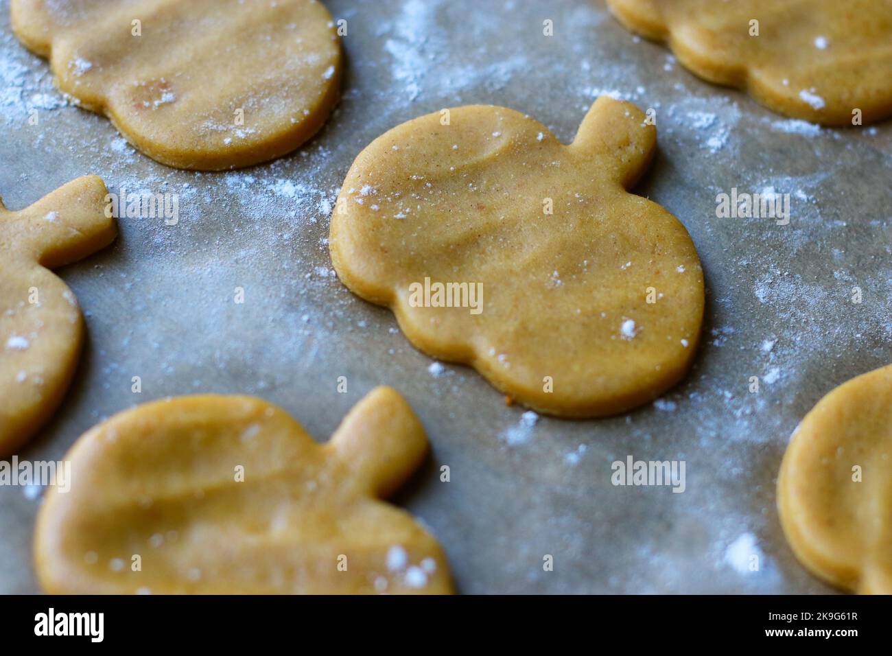 Schneiden Sie Plätzchen aus rohem Kürbisteig auf Backblech aus Stockfoto