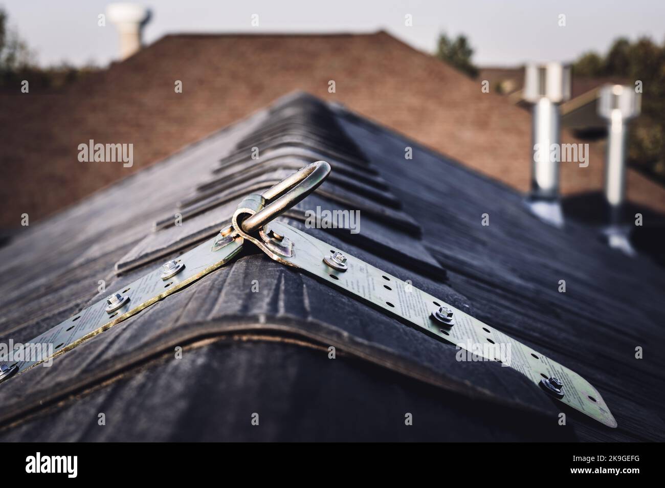 Selektiver Fokus auf einen provisorischen Metallanker, der auf der Spitze eines Daches zum Fallschutz installiert ist. Stockfoto