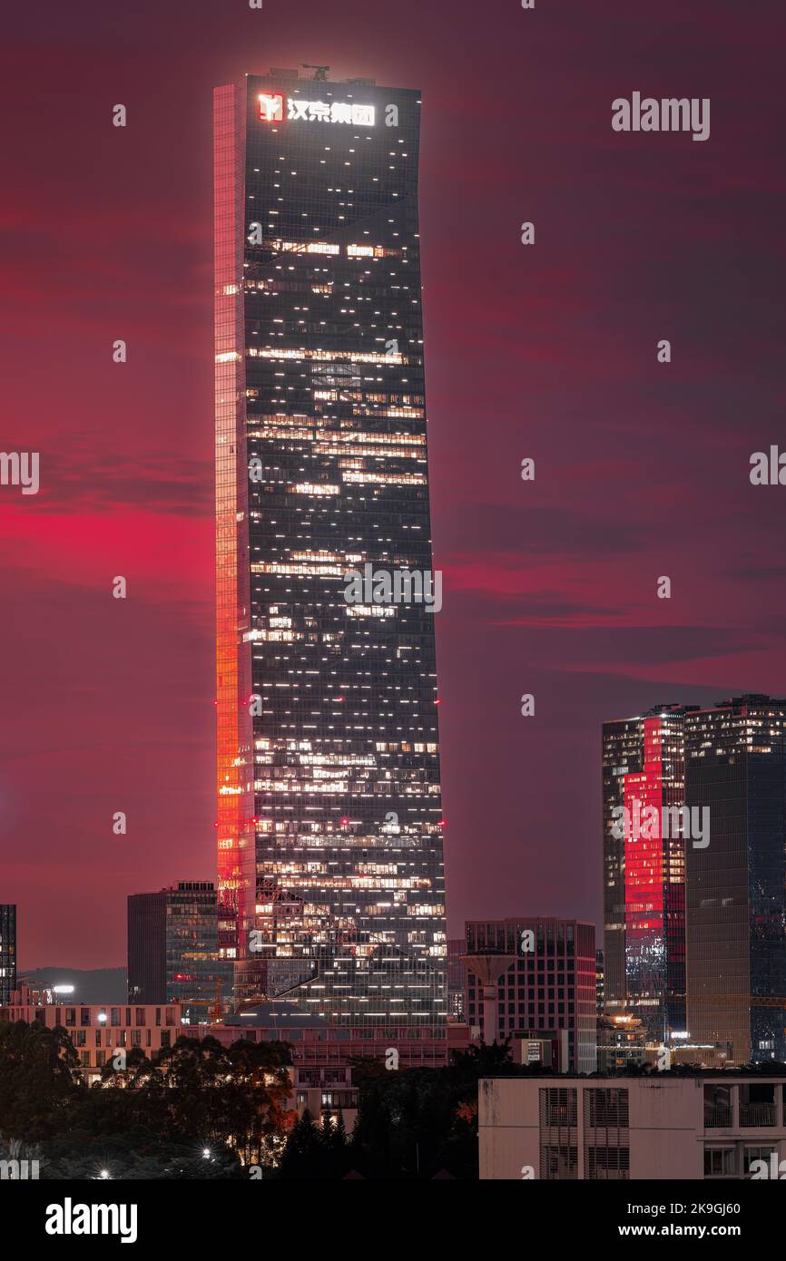 Ein moderner Wolkenkratzer, der am Abend mit einem rosa Himmel beleuchtet wird Stockfoto