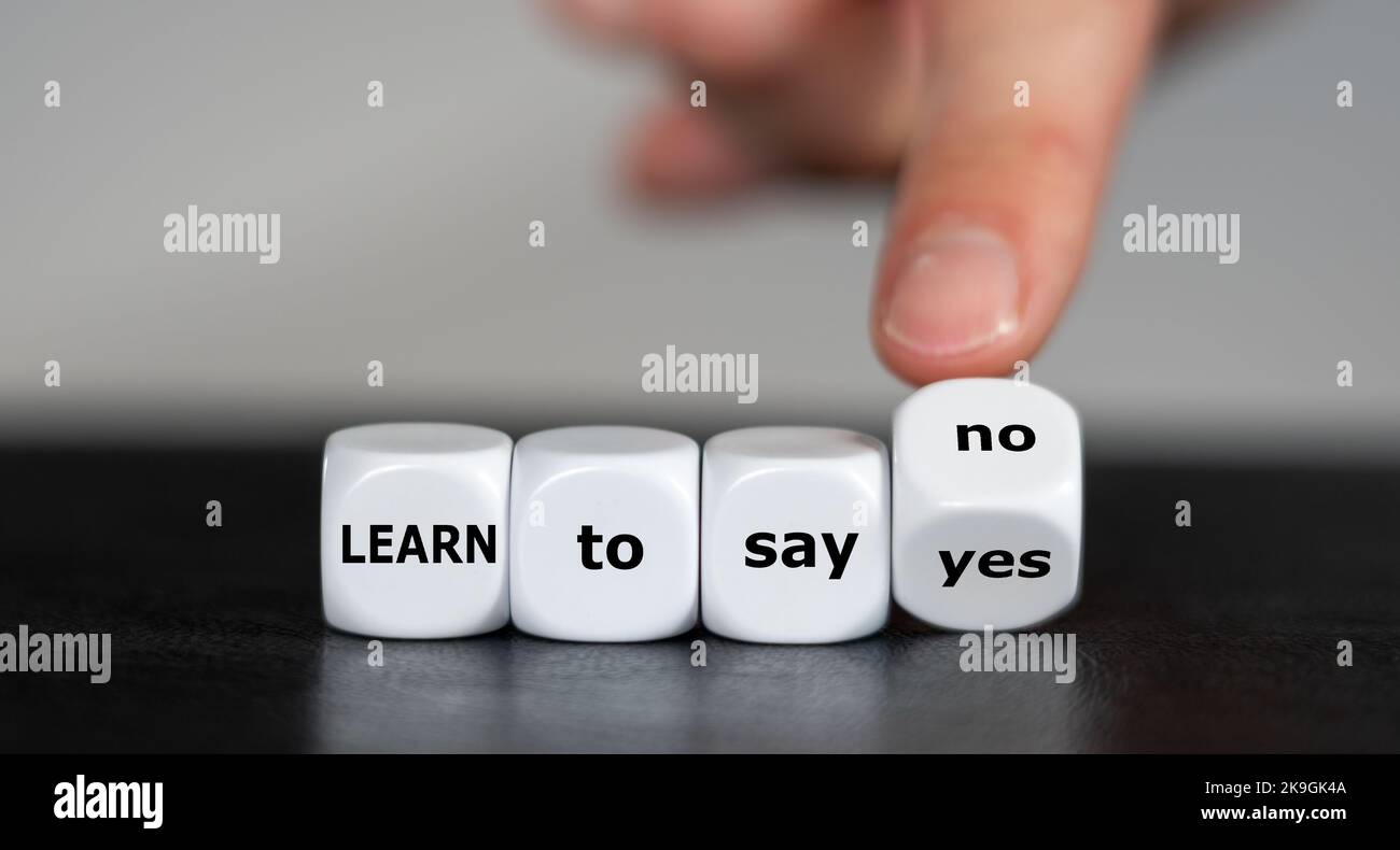 Die Hand dreht Würfel und ändert den Ausdruck „Lernen, ja zu sagen“ in „Lernen, nein zu sagen“. Stockfoto