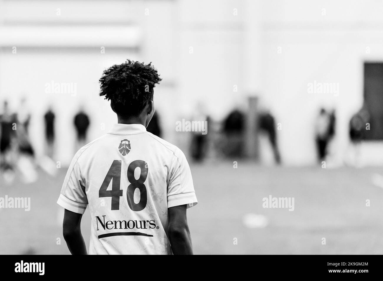 Eine Graustufe eines Lacrosse-Spielers im Feld Stockfoto