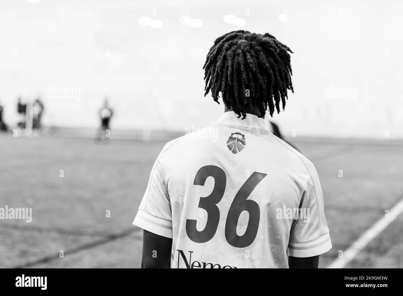 Eine Graustufe eines Lacrosse-Spielers im Feld Stockfoto