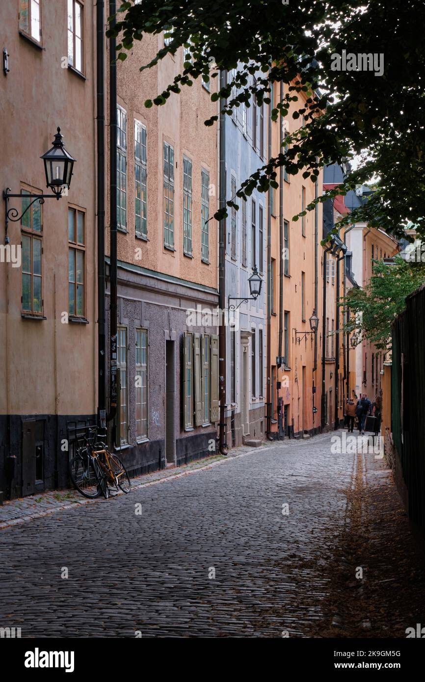 Stockholm, Schweden - 2022. September: Blick auf die farbenfrohe, schmale Altstadtstraße mit Kopfsteinpflasterstraße in Gamla Stan Stockfoto